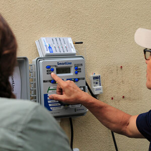 Technician and resident working on irrigation controller