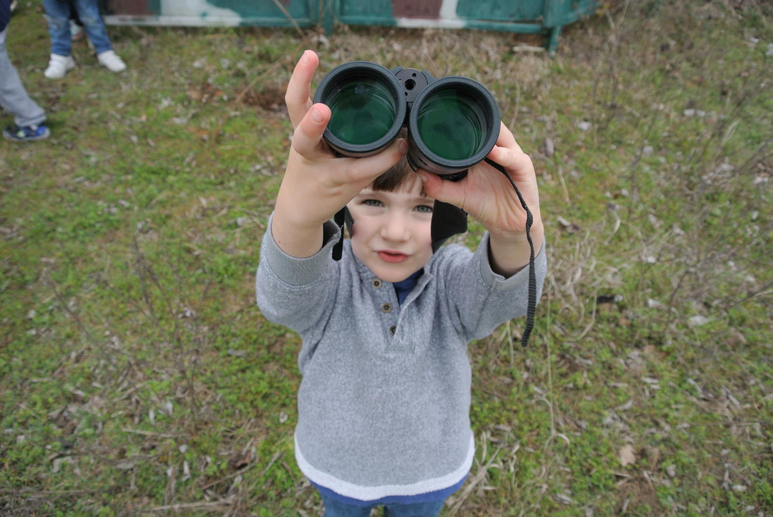 Young bird watcher holding up binoculars